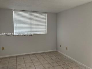 unfurnished room featuring light tile patterned floors