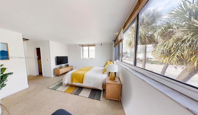 bedroom with light carpet and baseboards