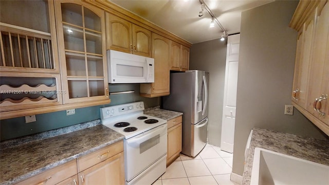 kitchen with sink, white appliances, rail lighting, and light tile patterned floors