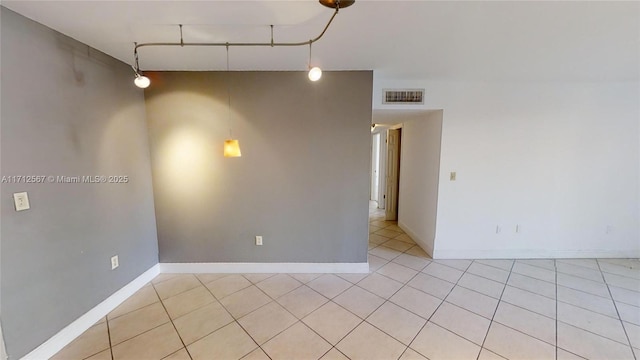 empty room with light tile patterned flooring, visible vents, and baseboards