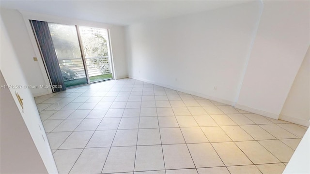 unfurnished room with light tile patterned floors and baseboards