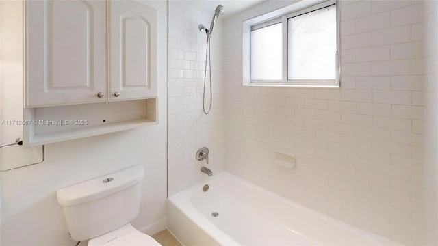 bathroom with tiled shower / bath combo and toilet