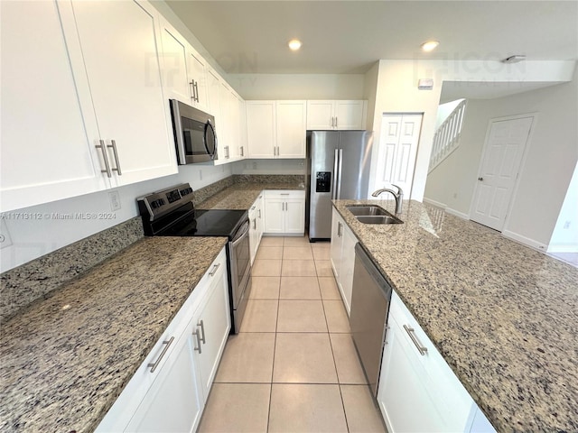 kitchen with white cabinetry, stainless steel appliances, and stone counters