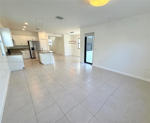 kitchen with a kitchen island, light tile patterned flooring, stainless steel refrigerator with ice dispenser, pendant lighting, and white cabinets