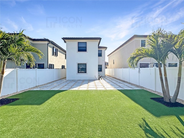 rear view of property with a patio and a lawn