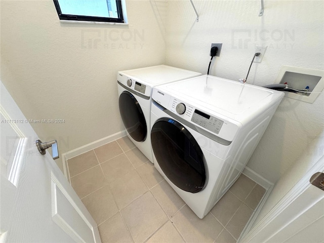 laundry area featuring washing machine and dryer and light tile patterned floors