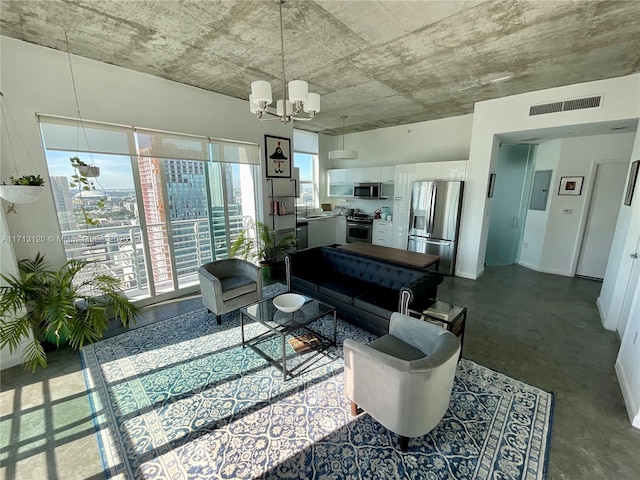 living area with an inviting chandelier, baseboards, concrete floors, and visible vents