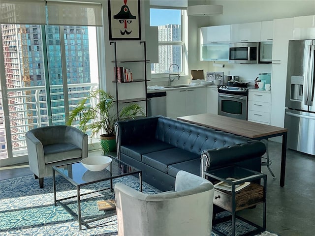 interior space featuring modern cabinets, stainless steel appliances, light countertops, white cabinetry, and a sink