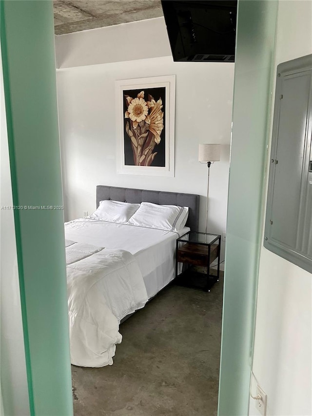 bedroom with electric panel and concrete floors