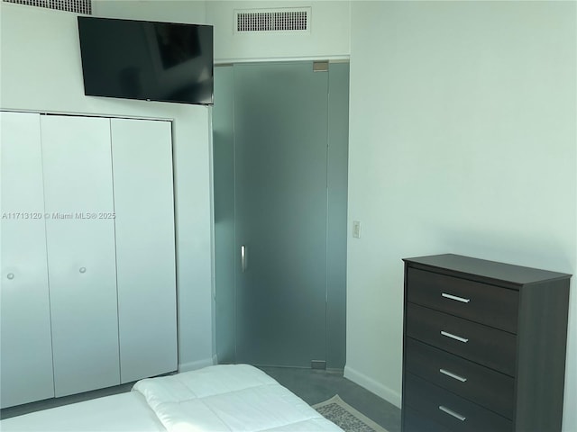 bedroom with baseboards, visible vents, and a closet