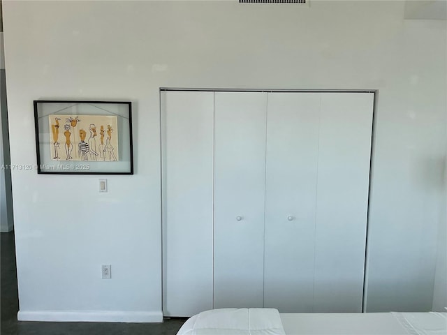 bedroom with a closet, baseboards, and visible vents