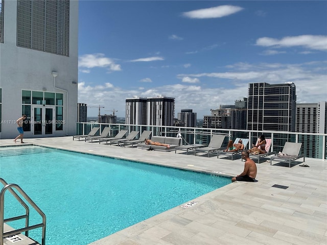 community pool with a patio and a city view