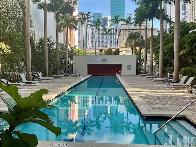 view of swimming pool featuring a patio and a city view