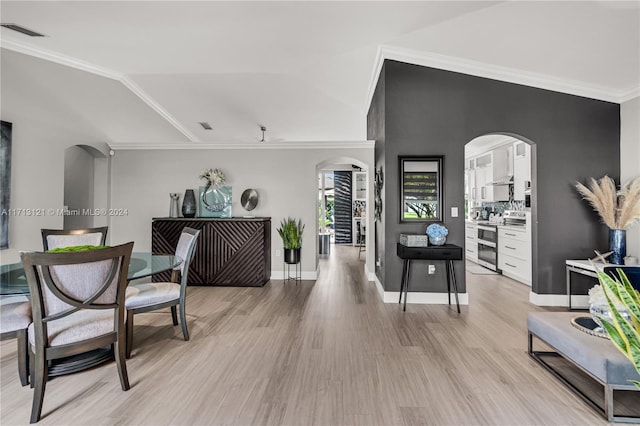 interior space with light wood-type flooring, vaulted ceiling, and ornamental molding