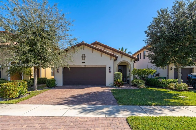 mediterranean / spanish-style house with a front yard and a garage