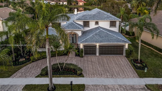 view of front of property featuring decorative driveway, stucco siding, and a garage