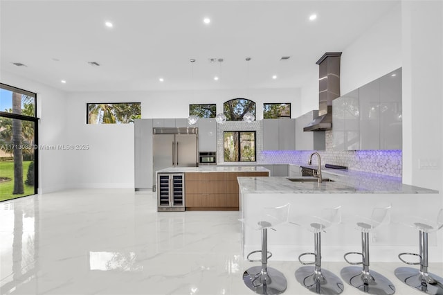 kitchen with stainless steel appliances, wine cooler, marble finish floor, a sink, and modern cabinets