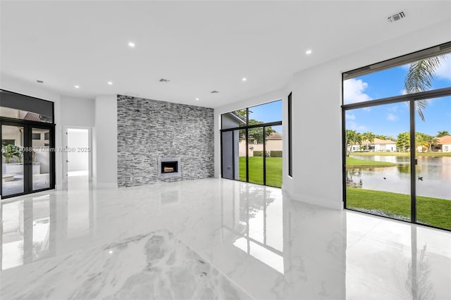 unfurnished living room featuring marble finish floor, recessed lighting, a water view, and visible vents