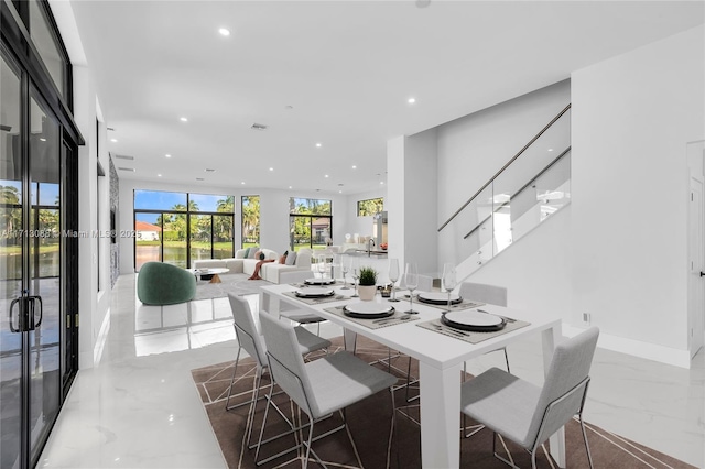 dining space with a wall of windows, marble finish floor, stairs, recessed lighting, and french doors