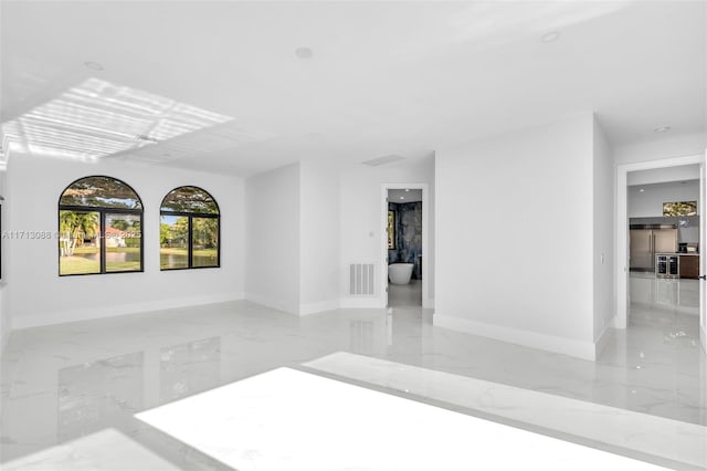unfurnished room featuring baseboards, marble finish floor, and visible vents