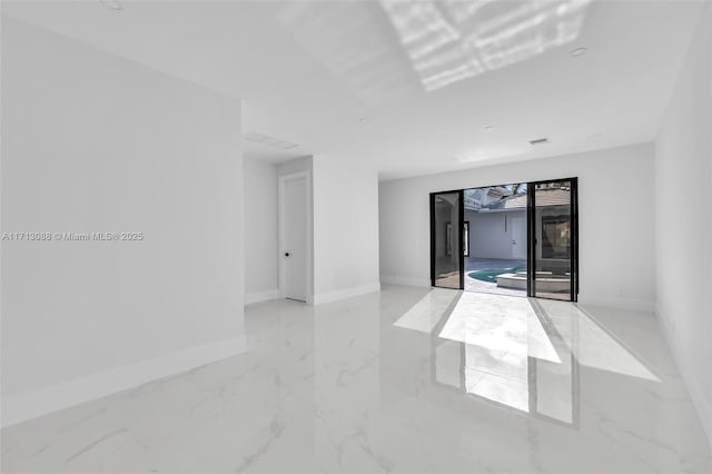 spare room featuring marble finish floor, baseboards, and visible vents