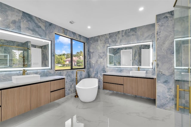 bathroom with marble finish floor, visible vents, a sink, and a stall shower