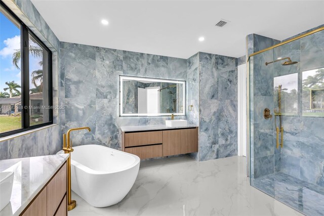 bathroom featuring vanity and tile walls