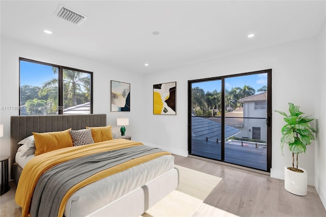 bedroom with access to exterior, multiple windows, visible vents, and light wood-style floors