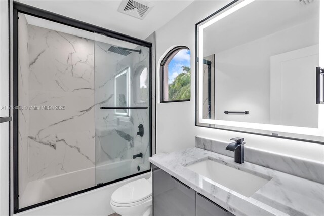 full bathroom with toilet, vanity, and combined bath / shower with glass door