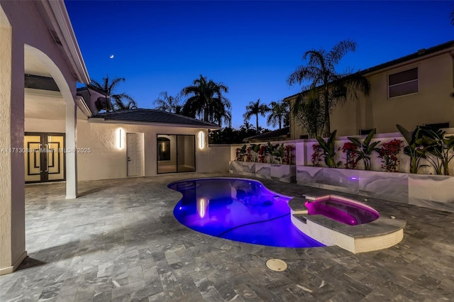 view of swimming pool featuring french doors, a pool with connected hot tub, fence, and a patio area