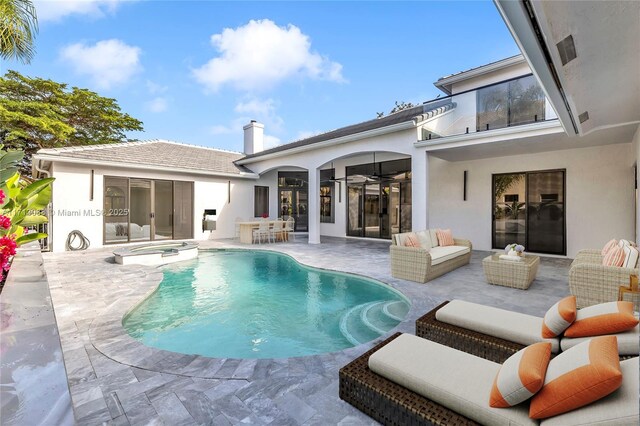 view of swimming pool with an outdoor living space, a patio area, and an in ground hot tub