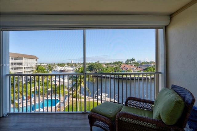 sunroom featuring a water view