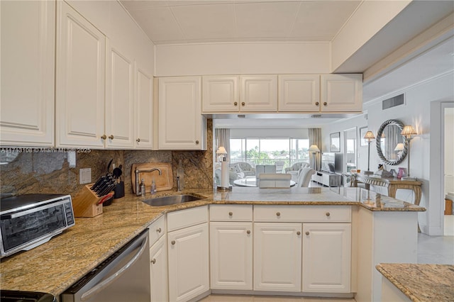 kitchen featuring a peninsula, a sink, visible vents, light stone countertops, and dishwasher