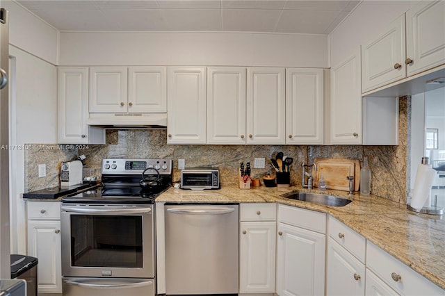 kitchen featuring sink, light stone countertops, tasteful backsplash, white cabinetry, and stainless steel appliances