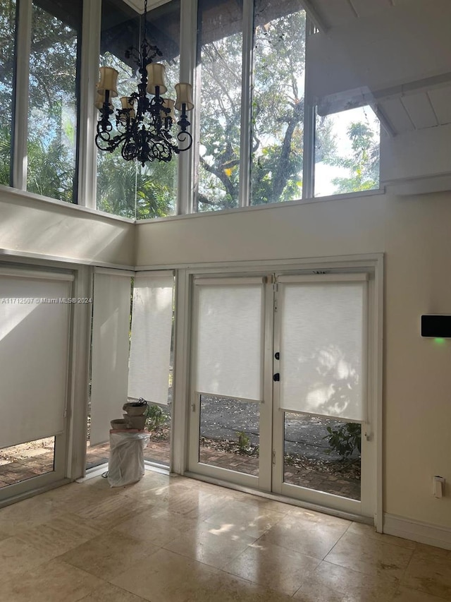 doorway to outside featuring an inviting chandelier and a healthy amount of sunlight