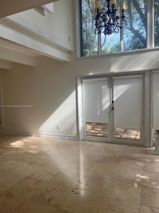 interior space with beamed ceiling and a chandelier