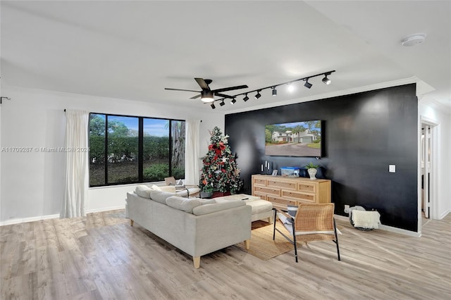 living room with light hardwood / wood-style floors, track lighting, and ceiling fan