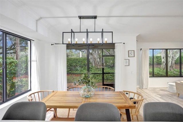 dining room featuring an inviting chandelier, ornamental molding, and light wood-type flooring