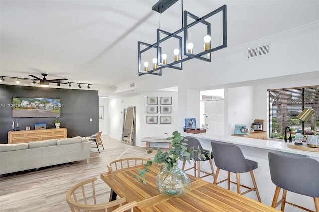 dining area featuring track lighting, light hardwood / wood-style flooring, and ceiling fan