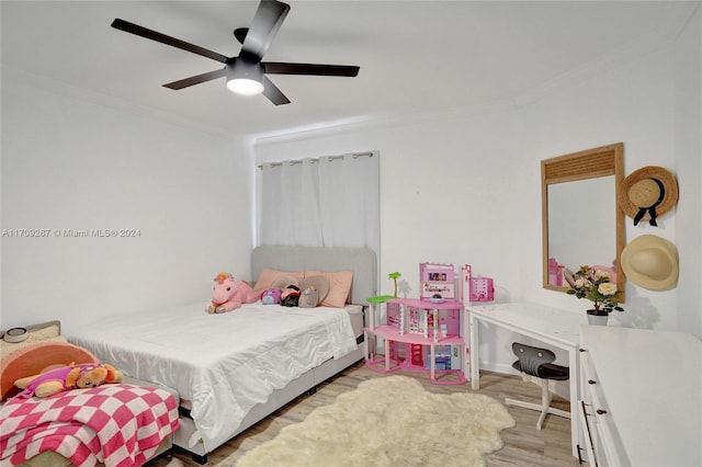 bedroom featuring ceiling fan, light hardwood / wood-style floors, and crown molding