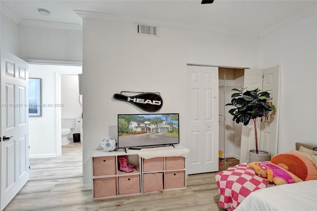 bedroom featuring a closet, ornamental molding, and light hardwood / wood-style flooring