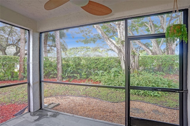 unfurnished sunroom with ceiling fan