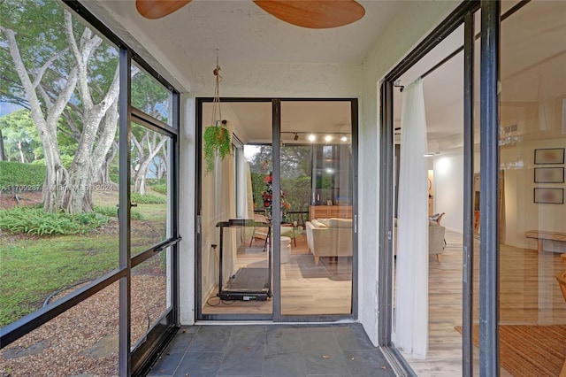 unfurnished sunroom featuring ceiling fan