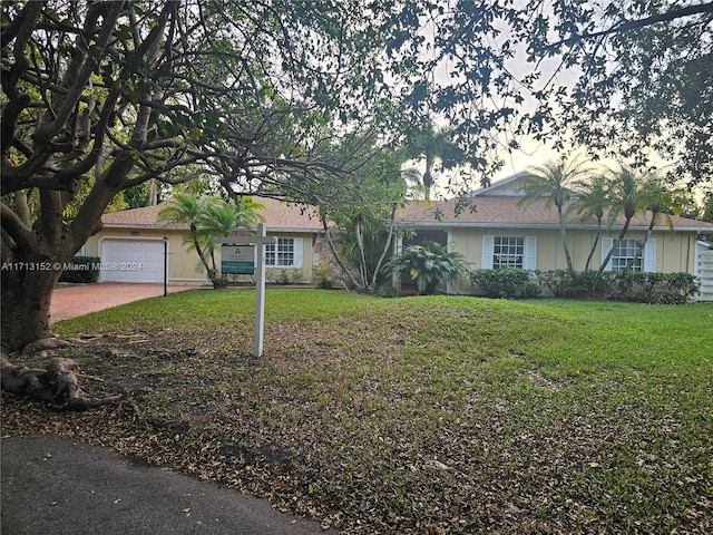 single story home featuring a front yard and a garage