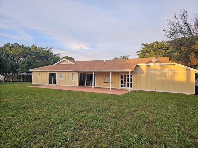 back of house with a lawn and a patio area