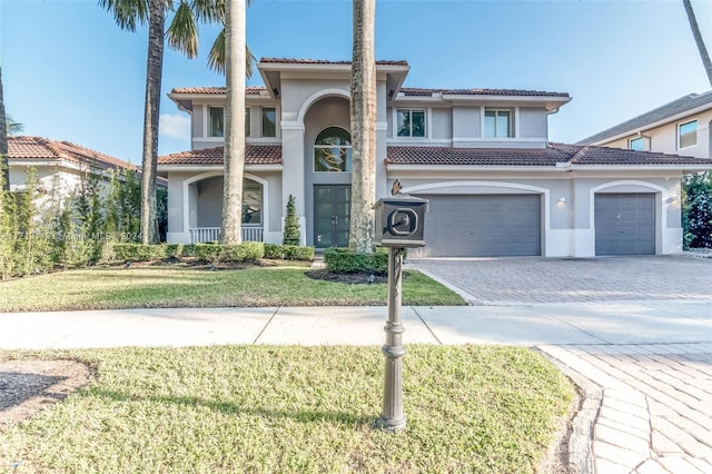 mediterranean / spanish home with a front yard and a garage