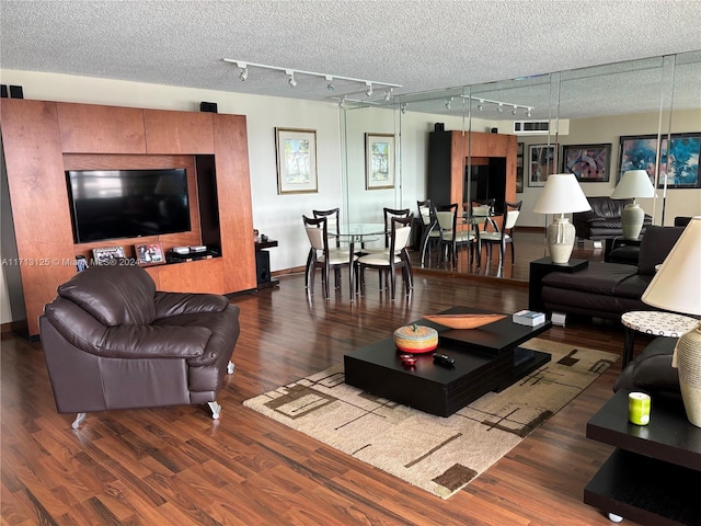 living room with dark hardwood / wood-style flooring, a textured ceiling, and track lighting