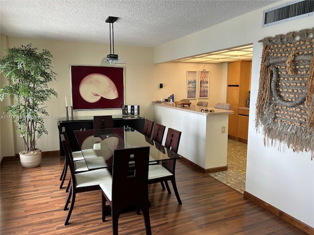 dining space with a textured ceiling and dark wood-type flooring