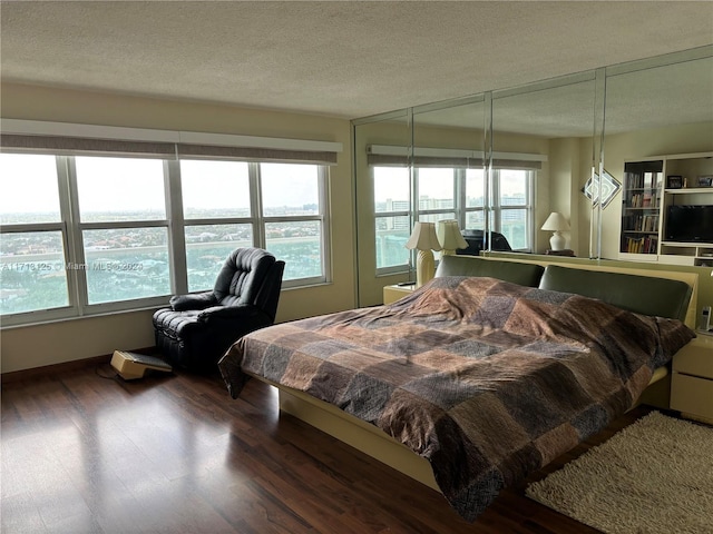 bedroom featuring a textured ceiling and dark hardwood / wood-style floors