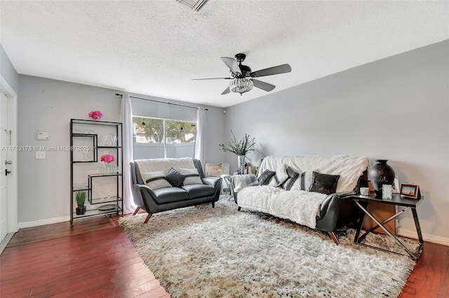 living area featuring visible vents, a textured ceiling, baseboards, and hardwood / wood-style floors